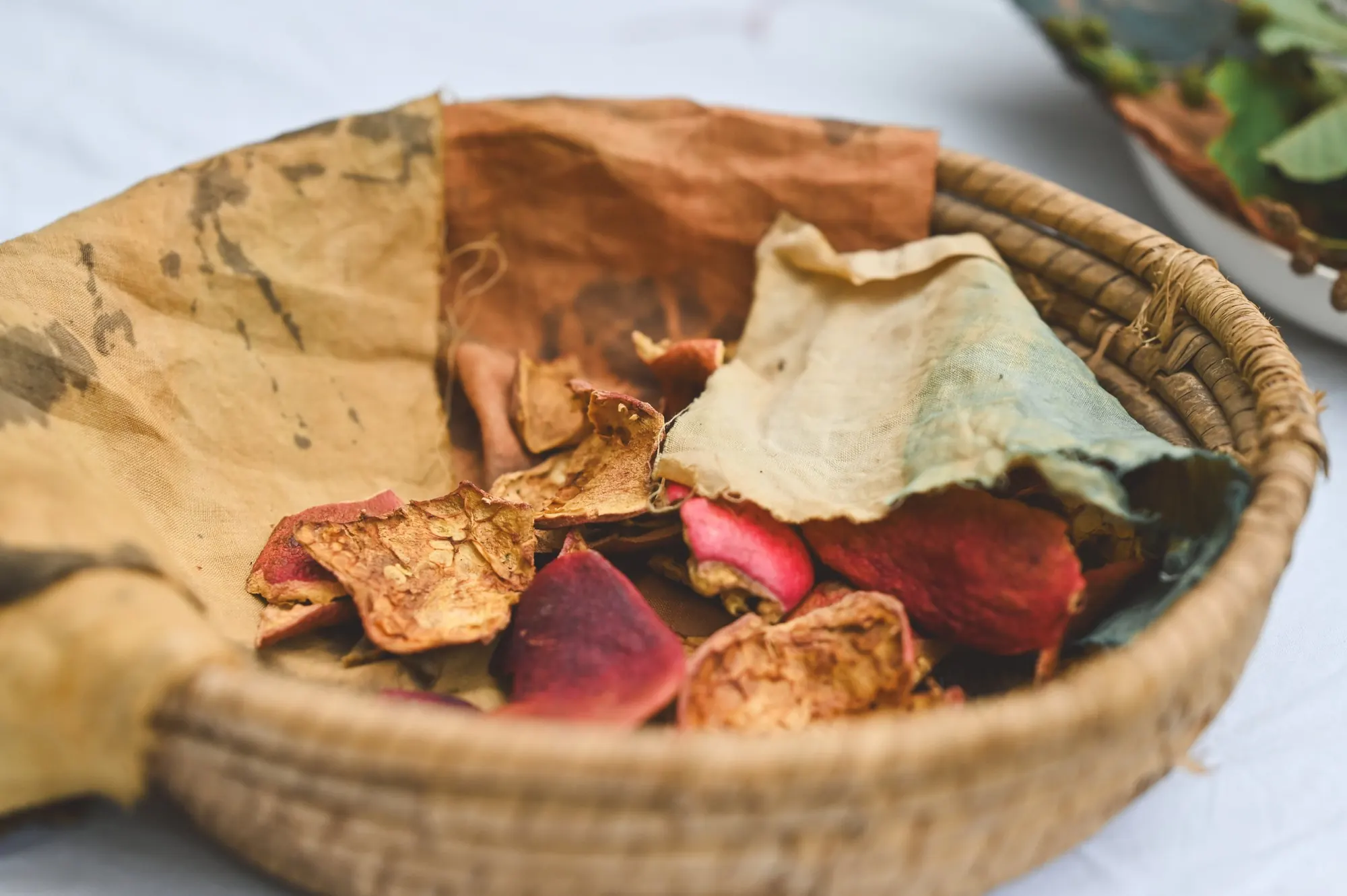 A basket of dyed cloth and dried petals