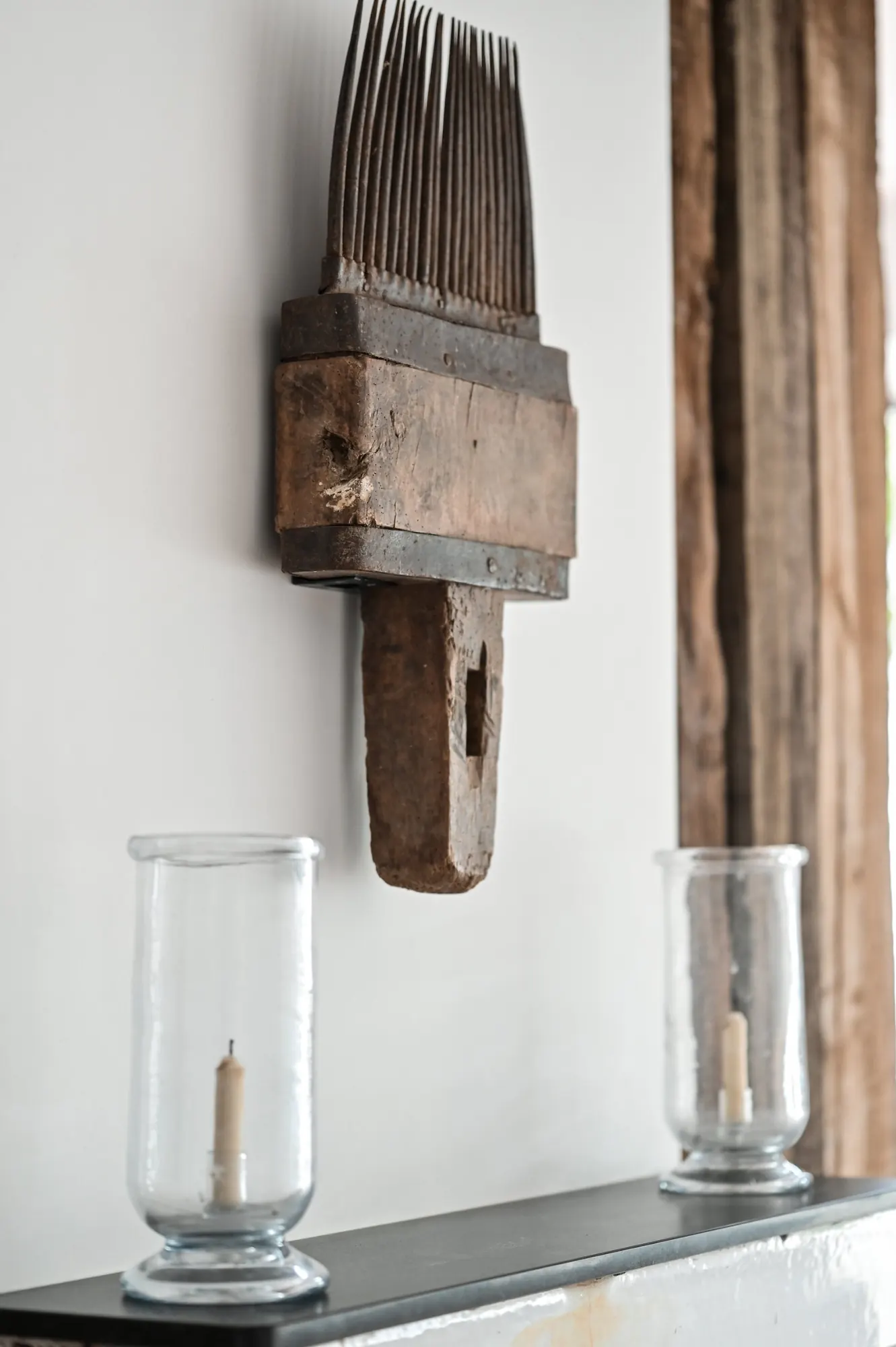 An old wooden flax comb above two candles