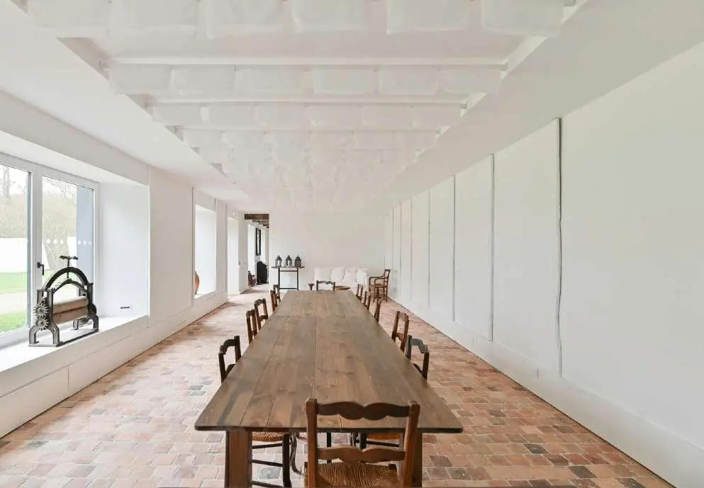 Salle à manger du Teinturier avec une longue table en bois et un sol en briques