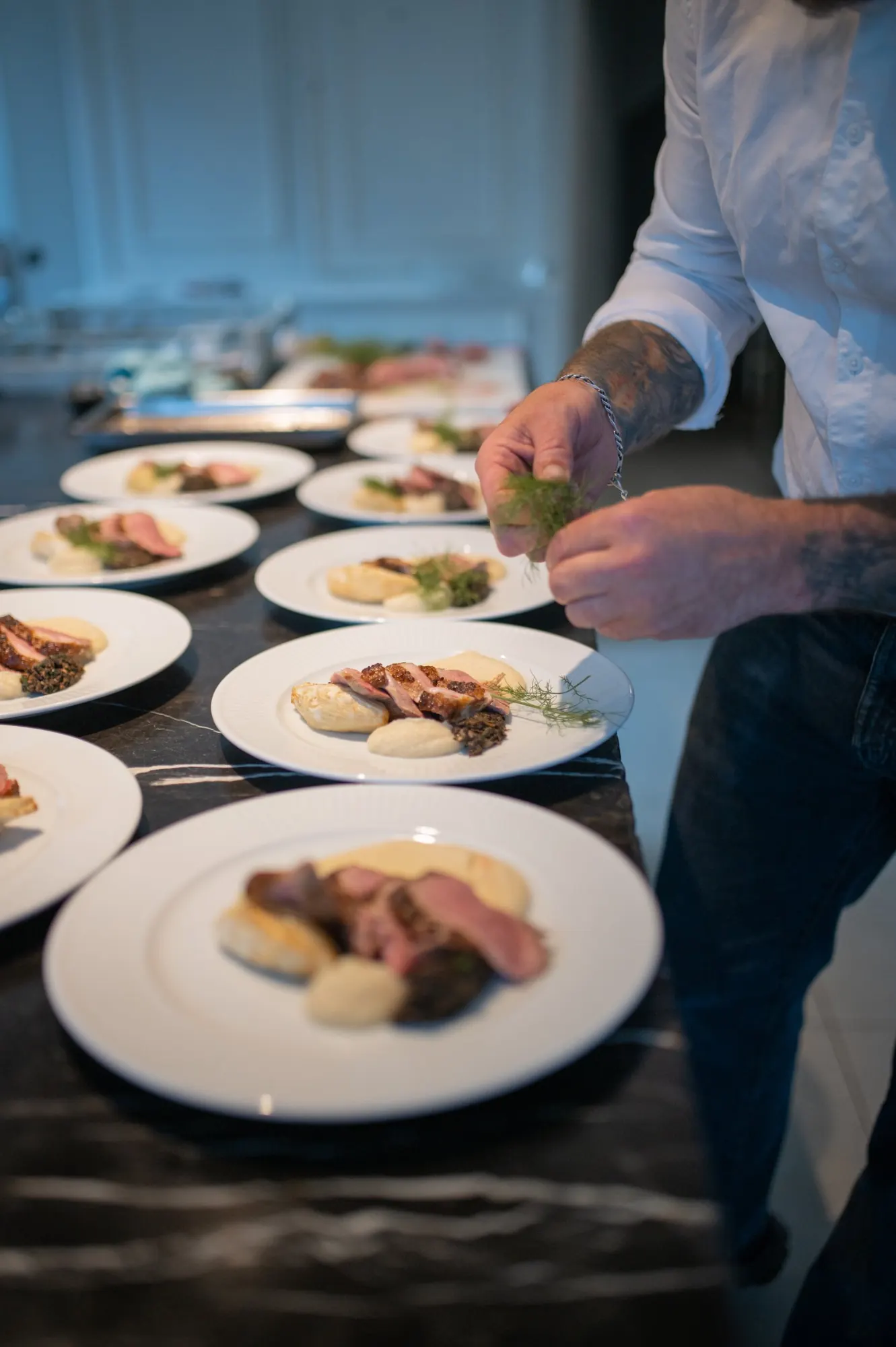 A chef plating duck with fennel