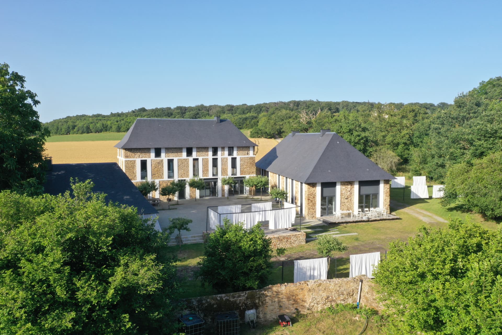 The restored stone buildings seen from above, among trees and fields