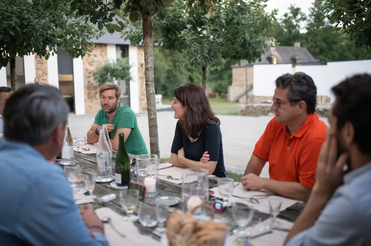 Participants déjeunant ensemble en extérieur dans la cour du domaine