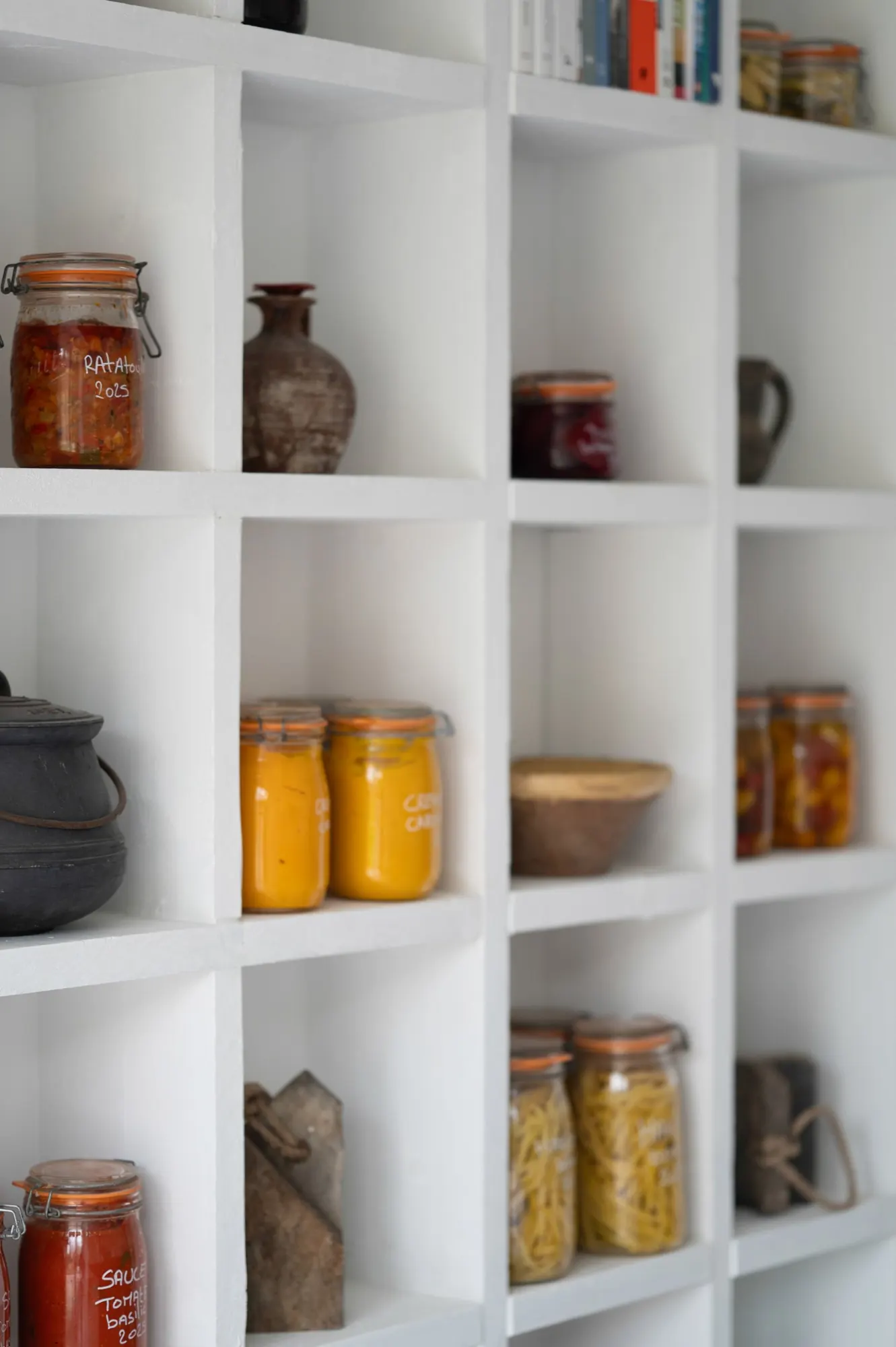 White pantry shelves with jars and pottery