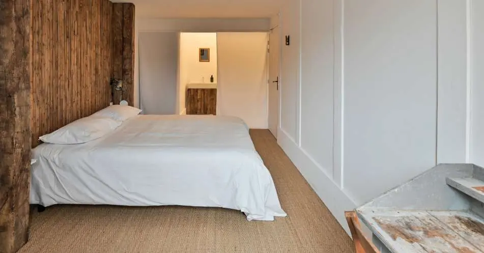 Chambre avec lit blanc et boiseries