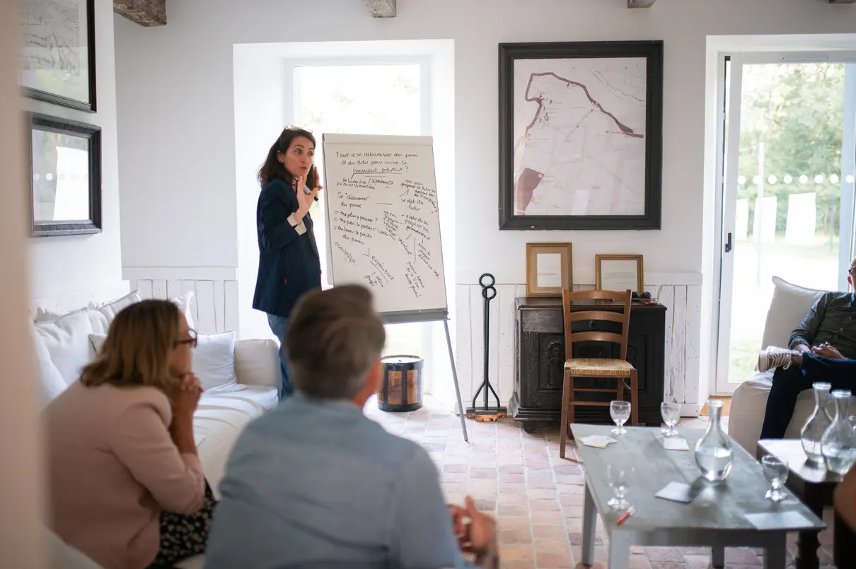 Formatrice animant un atelier devant un paperboard dans un salon du domaine