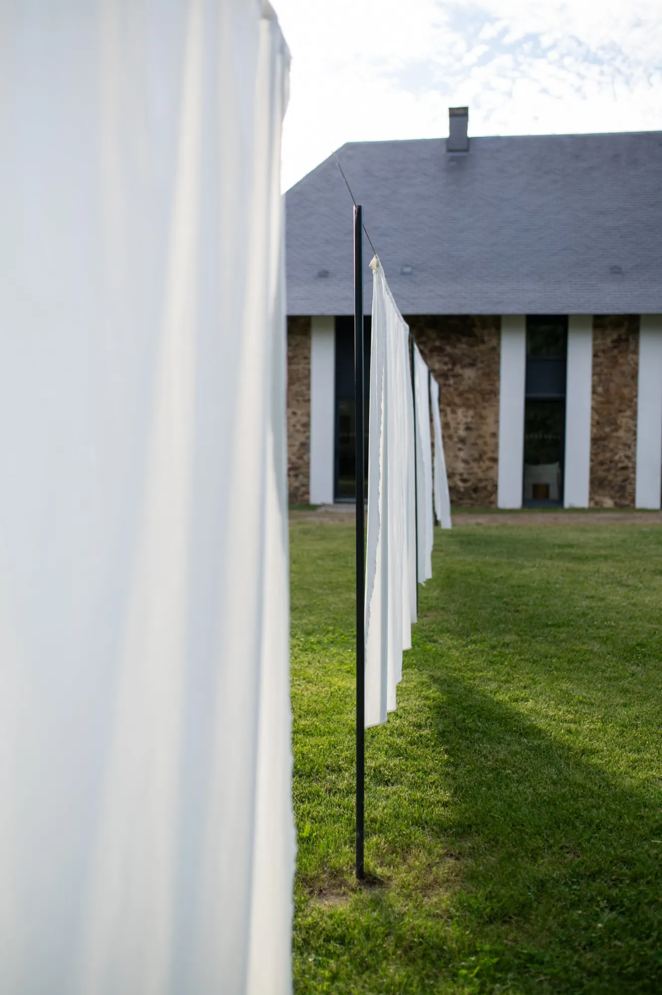 White sheets on a line in front of a slate-roofed stone building