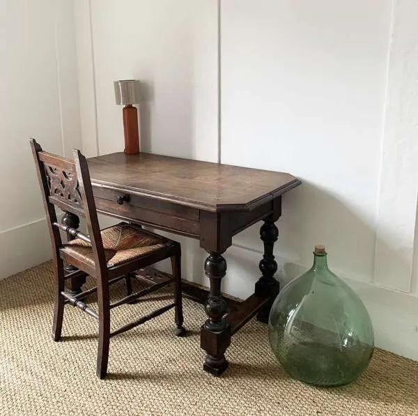 Bureau ancien et dame-jeanne verte dans une chambre du Magasin